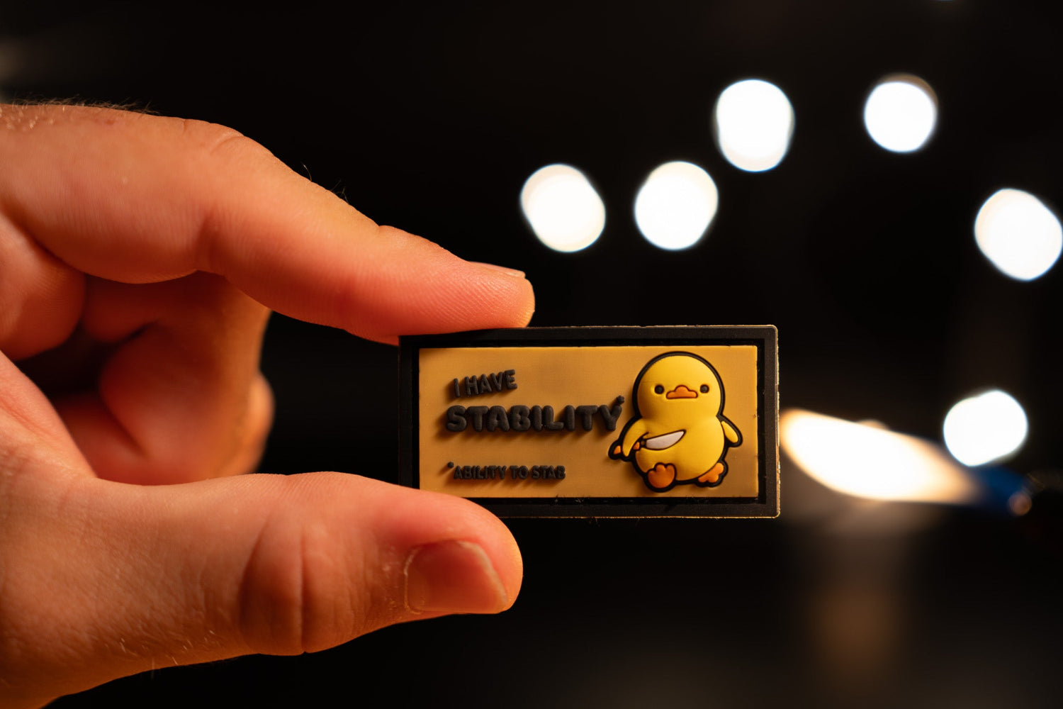 Hand holding a small patch and text against a blurred light background