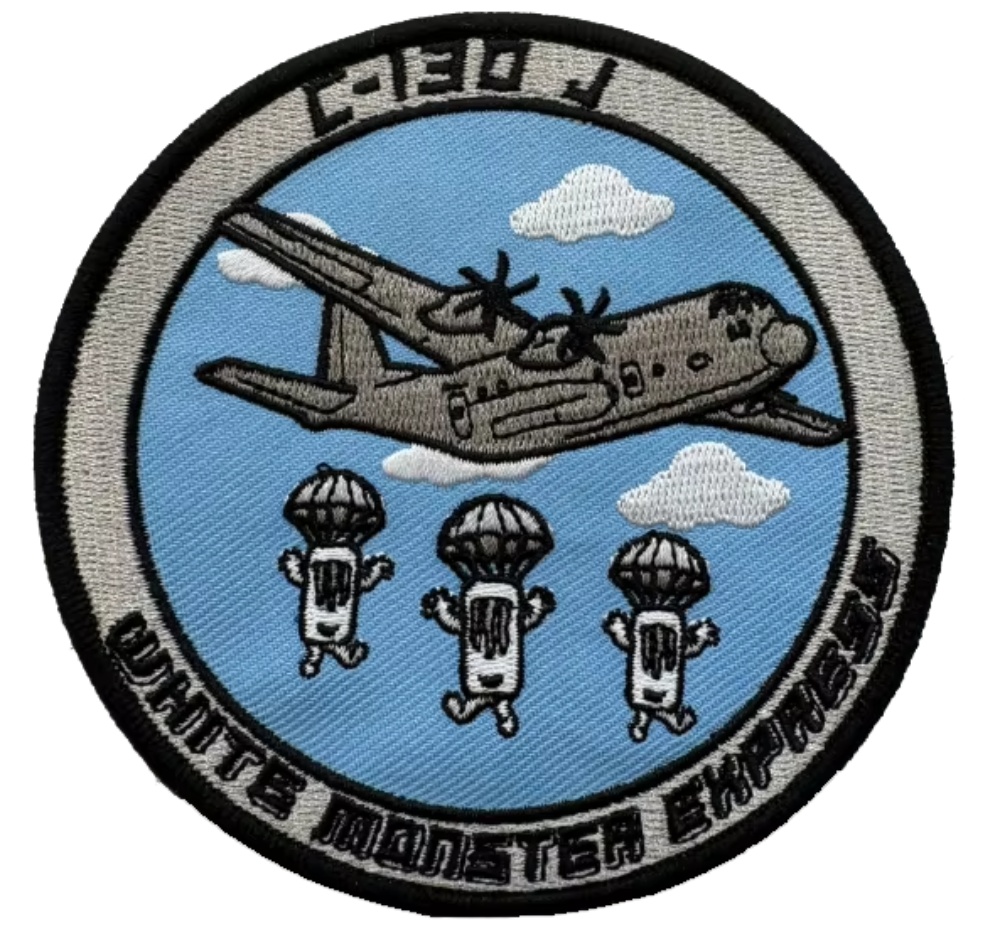 Embroidered patch with airplane and parachuting figures on a blue background